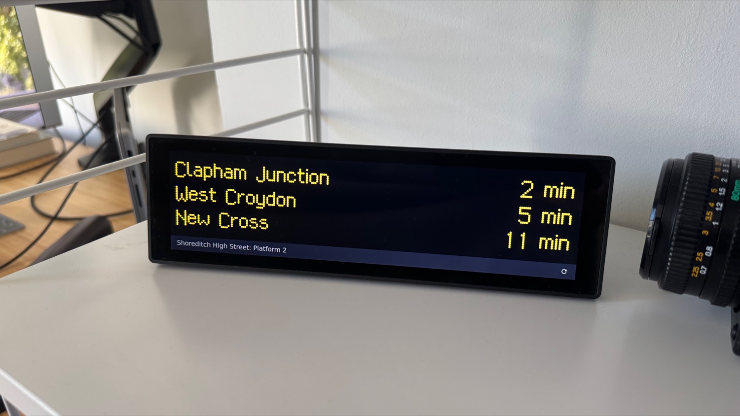 A small screen showing arrivals at Shoreditch High Street